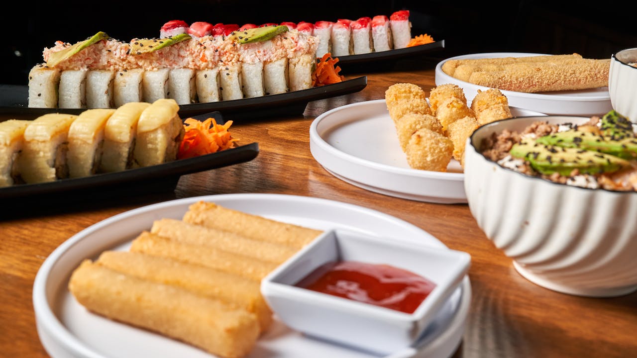 Delicious assortment of sushi and Asian dishes elegantly presented on a wooden table.