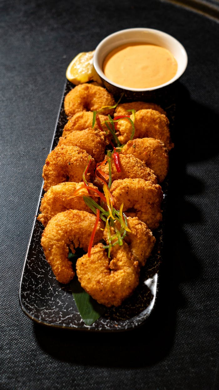 Crispy fried shrimp served with a creamy tangy dipping sauce and lemon wedge.